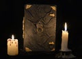 Mystic still life with black magic book and two burning candles Royalty Free Stock Photo