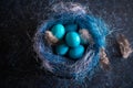 Blue Easter eggs with twigs in a decorative nest