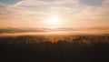 Sea of clouds over the forest. Epic November sky before sunset. Frosted fir trees in autumn, immersed in golden light. Royalty Free Stock Photo