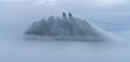 Mystical foggy lansdcapes along the coast of Vagar Island, Faroe Islands. The rocky peaks of Tindholmur near Mykines island