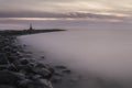 Mystical foggy sea and rocky shore in the evening