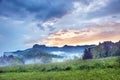 Mystical landscape with sunrise and morning fog in the mountains Royalty Free Stock Photo