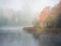 Mystical morning autumn landscape with fog over the lake. Royalty Free Stock Photo