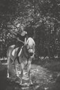 Woman with a horse at forest, mystical scene