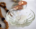 mystical still life. burning candles, a bowl of water and a rosary on a light background. the concept of divination, clairvoyance.