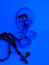 mystical still life. burning candles, magic glass ball and rosary blue background with reflection in the mirror. Royalty Free Stock Photo