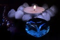 mystical still life. burning candles, rosaries and magic glass stones on a dark background. the concept of divination.