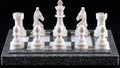 Mystical strategy is represented by chess pieces that glow green, positioned on a black marble board Royalty Free Stock Photo