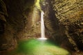 Mystical view of the rocky amphitheatre with a green pool and a white beam of water. 15-metre-high Kozjak Waterfall