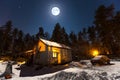 Mystical village house covered with snow in moonlight