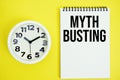 Myth Busting text with alarm clock flat lay on yellow background Royalty Free Stock Photo