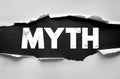 MYTH text revealed under torn paper background with grunge texture. Concept for false belief, story, misunderstanding, or Royalty Free Stock Photo