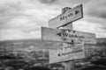 myth wisdom apocalypse text engraved on old wooden signpost outdoors in nature