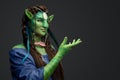 Mythical female elf with green skin and outstretched arm