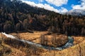 Mzymta mountain river in autumn forest under blue sky in Caucasus mountains. Sochi, Russia. Scenic sunny landscape