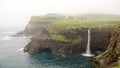 MÃÂºlafossur Waterfall in GÃÂ¡sadalur village on a misty day in bad weather on the Faroe Islands in Denmark.