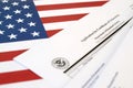 N-600 Application for Certificate of Citizenship blank form lies on United States flag with envelope from Department of Homeland