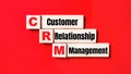 n a bright red background, wooden cubes and blocks with the text CRM Customer Relationship Management. Manufacturing of wooden Royalty Free Stock Photo