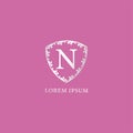 N Letter Intial logo design template. Luxury silver decorative floral shield illustration. Isolated on pink color background.