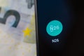 N26 Mobile Bank app on the smartphone screen in a main focus and the euro banknote at the blurred background