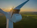 Nacelle of a wind turbine with fields in the backgroundagainst the sun. Royalty Free Stock Photo