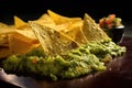 nacho chip dipped in guacamole, close-up shot