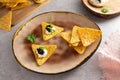 Nachos with black caviar and sour cream on a plate