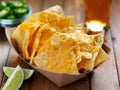 Nachos and cheese in tray with beer