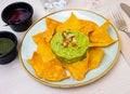 Nachos con guacamole. Corn chips.