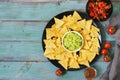 Nachos. Mexican food. Corn chips with sauce of salsa and guacamole on a green blue rustic background. Top view.