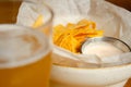 Nachos with sauce is served on plate next to glass of beer. Mexican appetizer is on the table as compliment from the restaurant. Royalty Free Stock Photo