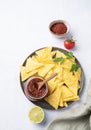 Nachos or tortilla with spicy tomato sauce on a plate with fresh lime on a light background. Corn chips with salsa sauce Royalty Free Stock Photo