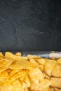 Nachos, triangle traditional Mexican corn appetizer, on black background, top view or flat lay with copy space for text