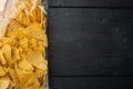 Nachos, triangle traditional Mexican corn appetizer, on black wooden background, top view or flat lay with copy space for text