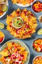 Nachos and various dips, top shot on a blue slate background Royalty Free Stock Photo