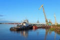 A tug with a barge and a floating crane at the pier in the port of Nadym in Siberia Royalty Free Stock Photo