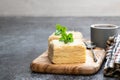 Napoleon cake slices with cup of coffee on gray table