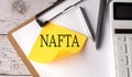 NAFTA word on yellow sticky with calculator, pen and clipboard