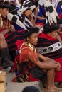 Naga tribesmen and young Naga boys wearing their traditional attire siting in central arena