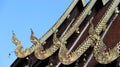 Nagas framing the pitch of temple roof decorated with stained glass Royalty Free Stock Photo