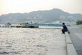 Nagasaki, Japan:August 31, 2016 - Portrait Asian man sitting on the seaside and looking out the ocean in the windy day. A man