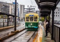 Nagasaki, Japan - 2 November 2020: Green and yellow tram on a rainy day in Nagasaki