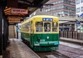 Nagasaki, Japan - 2 November 2020: Yellow and green tram on a rainy day in Nagasaki