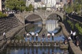 Students walking on stones in the Nakashima River in front of the Meganebashi Royalty Free Stock Photo