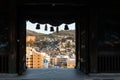 View of Nagasaki City through the opened wooden carved gate of Suwa Shinto Shrine on the hill, Japan