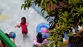 Chico leaves obscure the view of children enjoying swimming in the shallow waters of the resort pool