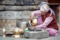 Old Indian woman cleans the dishes