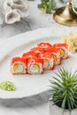 Nagiri Sushi roll with caviar ,shrimps, cheese and mango in the white plate on light marble background. Healthy sea food, hard