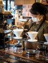 Nagoya, Aichi, Japan - Female barista wearing mask. Making pour over coffee in Kannon coffee.