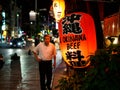 Naha, Japan - November18: Unknown man walks on the streets in front of Okinawa Beef lantern on November 18, 2015 in Naha